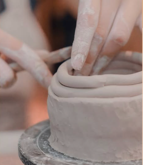 Person making pinch pot pottery
